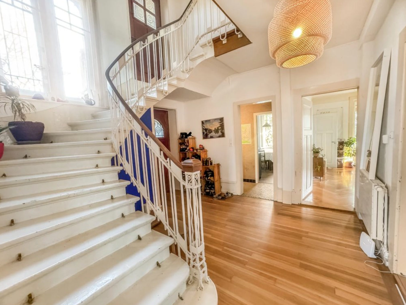 Hall d'entrée avec escalier courbe et parquet
