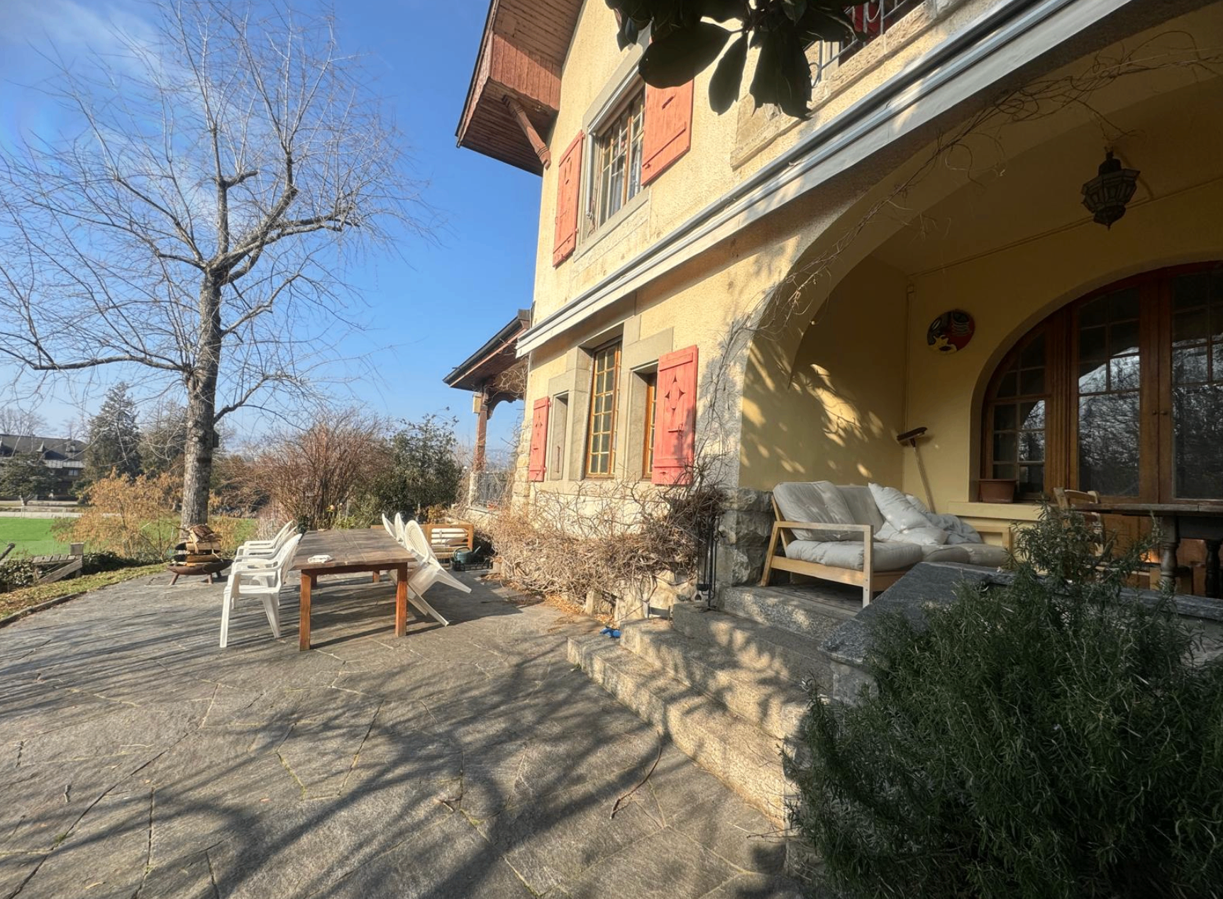 Façade de la maison avec terrasse couverte et espace repas extérieur
