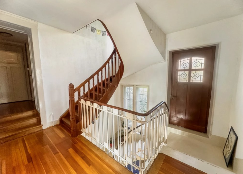 Palier d'étage avec escalier et porte d'entrée vitrée