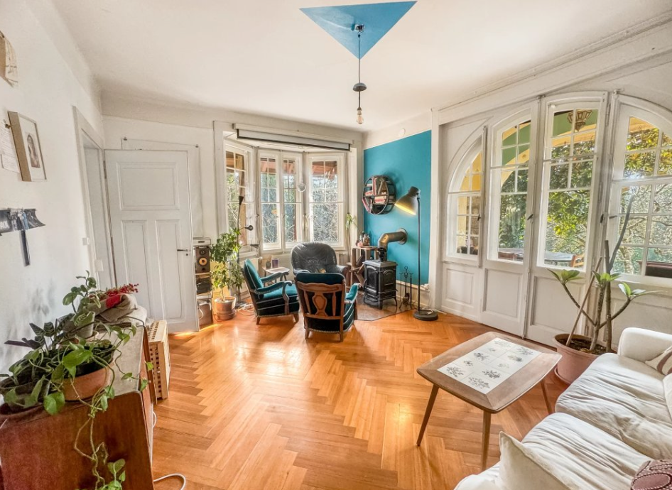 Salon avec parquet en chevrons, poêle et ouvertures cintrées